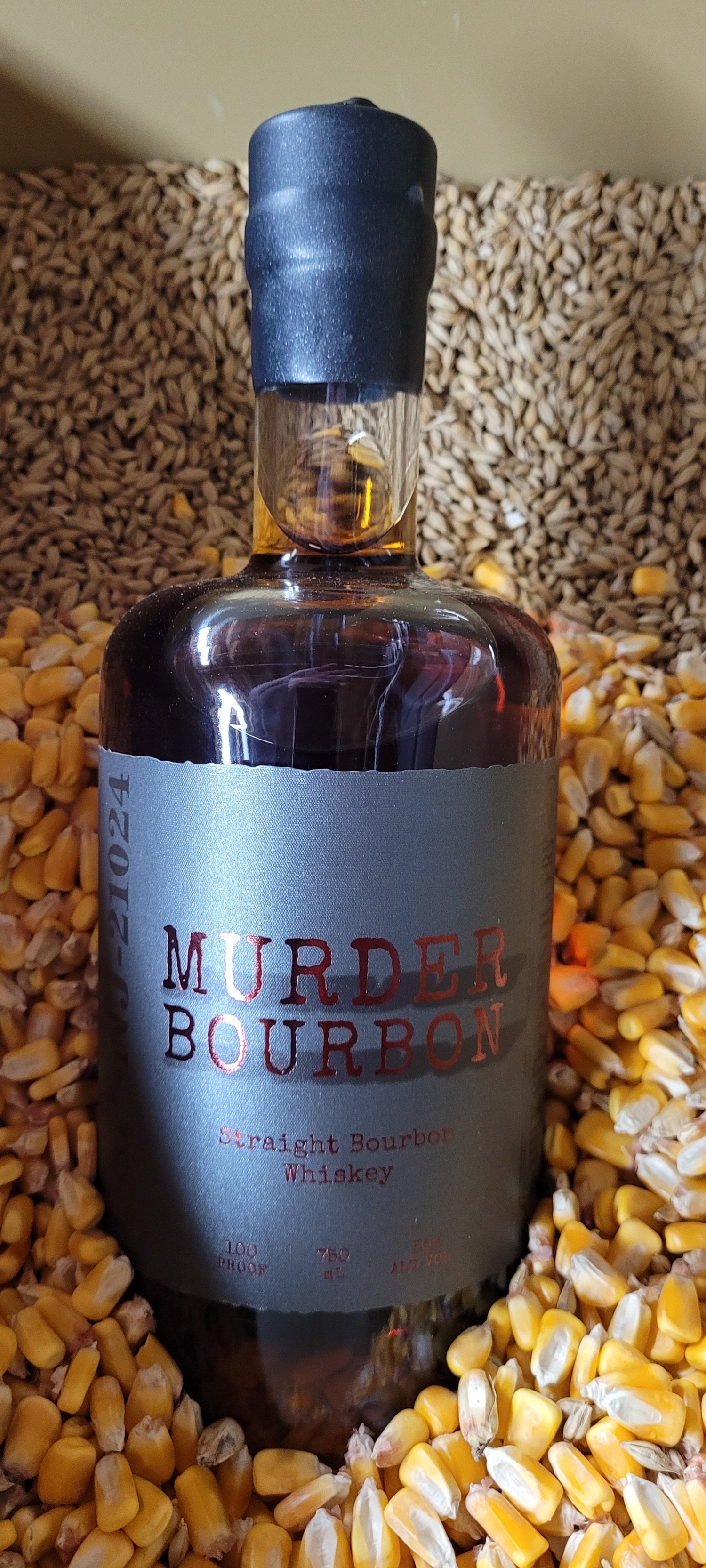 Murder Bourbon bottle lying in a wooden barrel of charred oak.