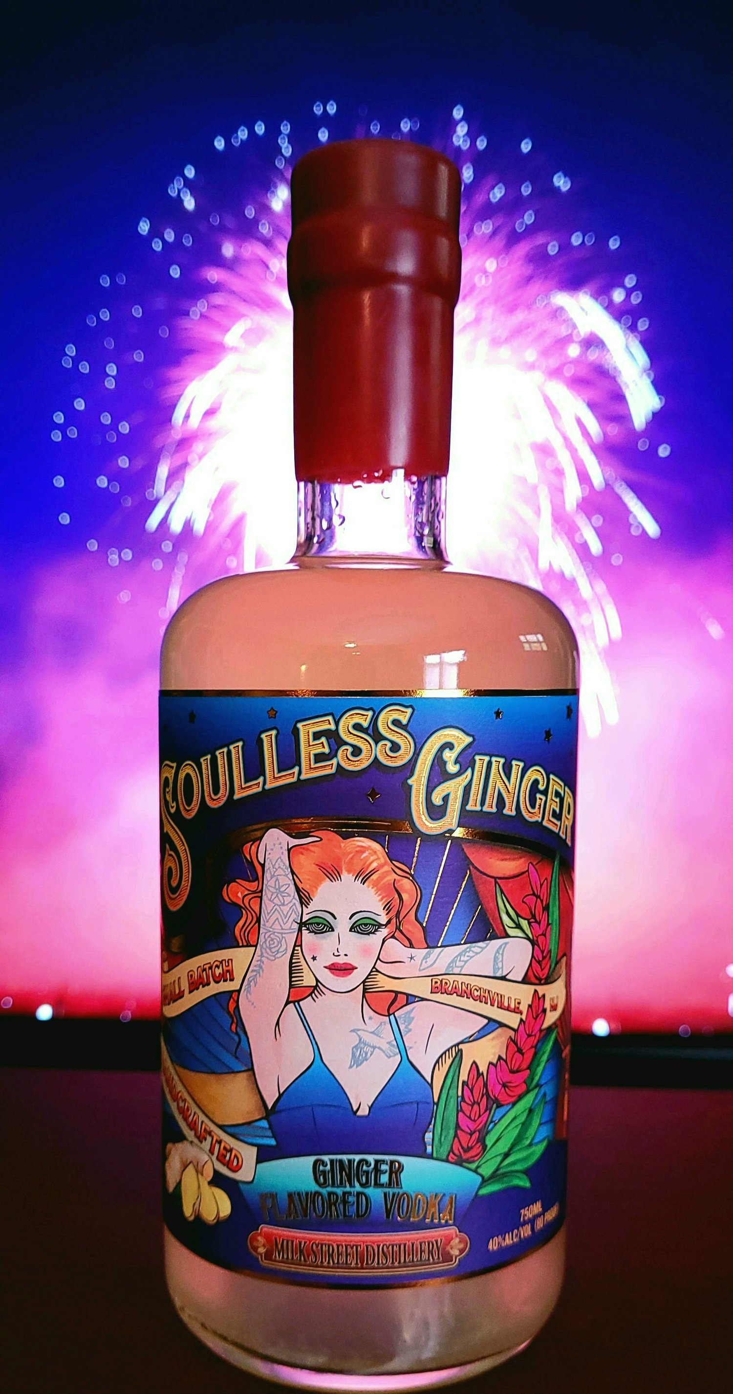 Soulless Ginger vodka bottle with fireworks behind it.